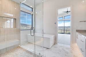 Full bathroom with a freestanding bath, vanity, a marble finish shower, and a mountain view
