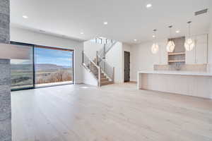 Unfurnished living room featuring a mountain view, light wood finished floors, and recessed lighting