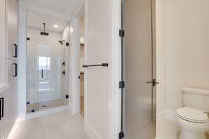 Bathroom featuring light tile patterned floors, a shower stall, and recessed lighting