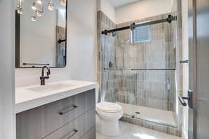 Full bathroom with vanity, a stall shower, and light tile patterned flooring