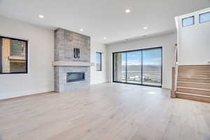 Unfurnished living room featuring a fireplace, light wood-style floors, and recessed lighting