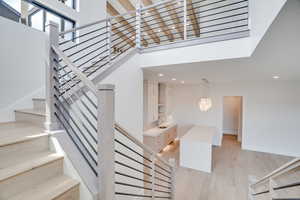 Stairway featuring wood finished floors and recessed lighting