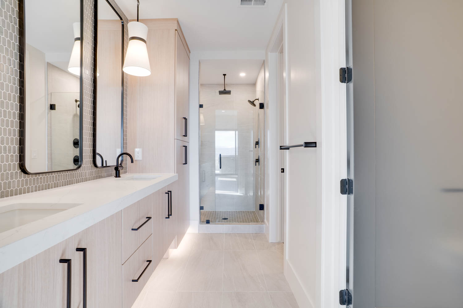 Bathroom with double vanity, a stall shower, and light tile patterned floors