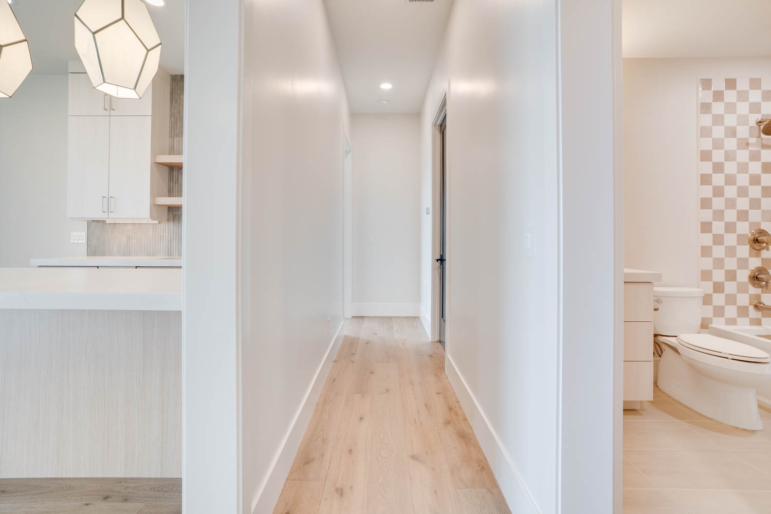 Corridor with light wood-style flooring and recessed lighting