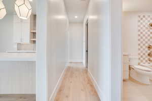 Corridor with light wood-style flooring and recessed lighting