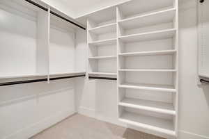 Walk in closet with light carpet