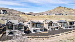 Back of house with a mountain view, a patio, a balcony, and a chimney