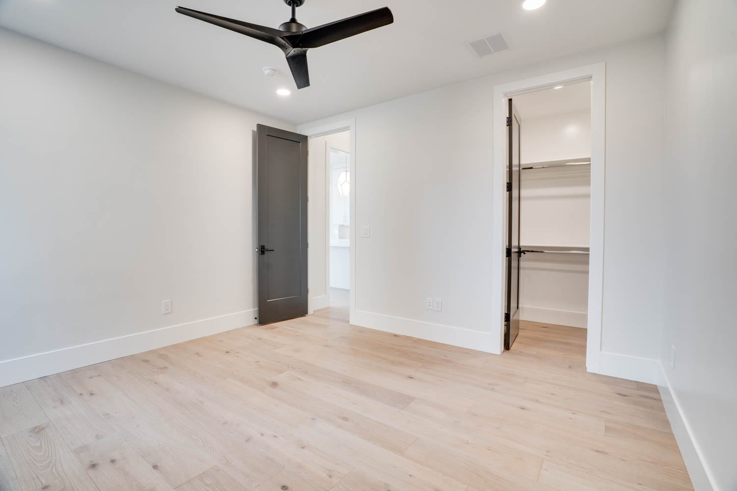 Unfurnished bedroom featuring light wood-style flooring, a walk in closet, recessed lighting, and ceiling fan
