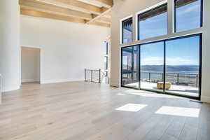 Empty room featuring a water and mountain view and light wood-style flooring