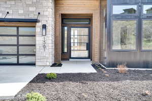 Doorway to property with a garage and stone siding