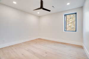 Unfurnished room featuring light wood-type flooring, a ceiling fan, and recessed lighting