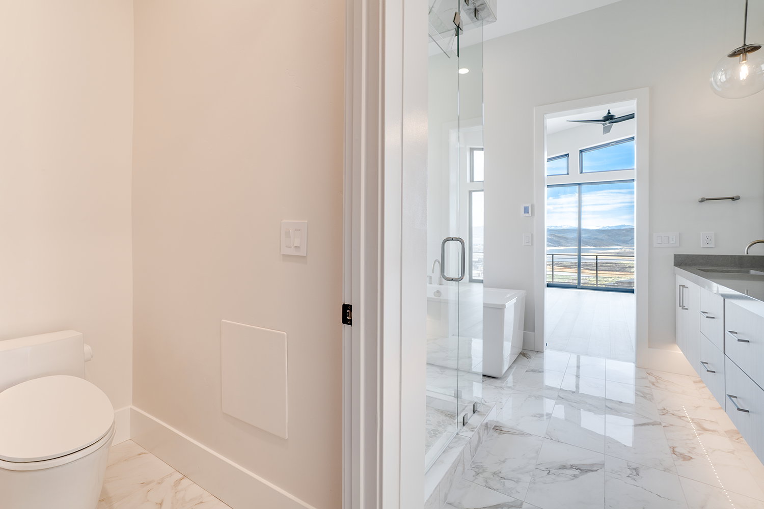 Full bathroom with light marble finish floors, vanity, a marble finish shower, a mountain view, and ceiling fan