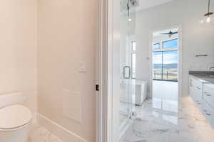 Full bathroom with light marble finish floors, vanity, a marble finish shower, a mountain view, and ceiling fan