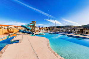 Community pool featuring a patio area, a water slide, and a mountain view