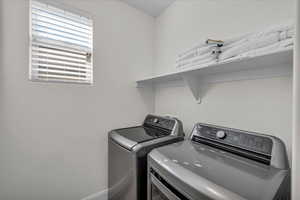 Laundry area featuring baseboards and separate washer and dryer