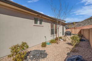View of side of property featuring a fenced backyard and stucco siding