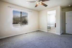 Unfurnished bedroom with light carpet, a ceiling fan, and ensuite bathroom