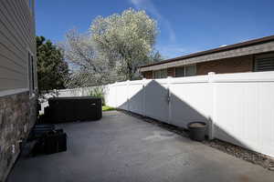 Fenced backyard featuring a patio area and a hot tub