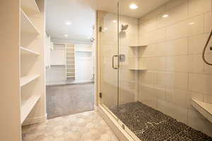 Full bathroom featuring a spacious closet, light colored carpet, a stall shower, and recessed lighting