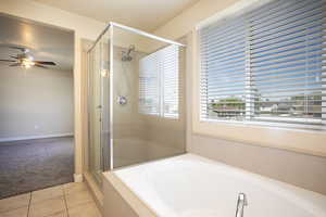 Full bath with light carpet, light tile patterned floors, a stall shower, a garden tub, and ceiling fan