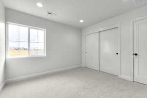 Unfurnished bedroom with light carpet, recessed lighting, and a closet