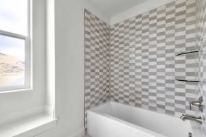 Full bathroom featuring plenty of natural light and shower / tub combination