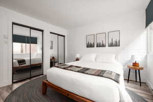 Bedroom with two closets and wood finished floors