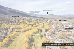 Aerial view of property and surrounding area with nearby suburban area, a local golf course, and property parcel outlined