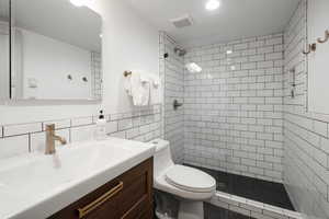 Full bathroom featuring vanity, tile walls, and a stall shower