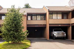 View of front of property featuring roof with shingles and brick siding