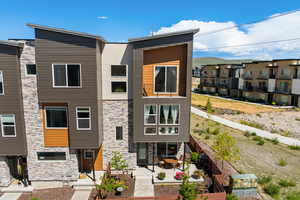 Rear view of property with stone siding