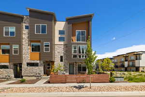 Contemporary home with stone siding and a balcony
