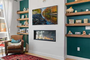 Sitting room featuring a glass covered fireplace