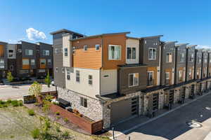 View of building exterior featuring an attached garage and a residential view