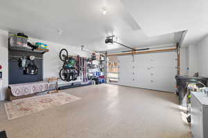 Garage featuring white refrigerator and a garage door opener