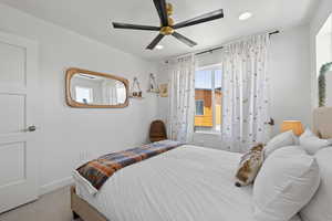 Carpeted bedroom featuring recessed lighting and a ceiling fan