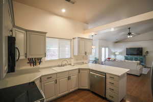 Kitchen with black appliances, a ceiling fan, open floor plan, dark wood finished floors, and light countertops