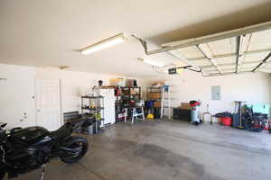 Garage featuring freestanding refrigerator and electric panel