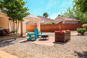 Fenced backyard featuring an outdoor living space with a fire pit, a patio area, and area for grilling