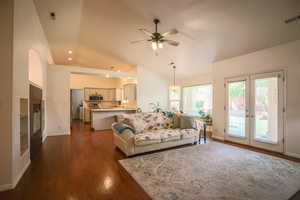 Living room featuring french doors, dark wood-style flooring, ceiling fan, vaulted ceiling, and recessed lighting
