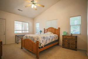 Bedroom featuring vaulted ceiling, ceiling fan, light colored carpet, and multiple windows