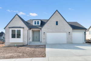 View of front of property with concrete driveway, brick siding, a garage, and roof with shingles
