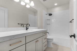 Bathroom with vanity, bathing tub / shower combination, and light tile patterned floors