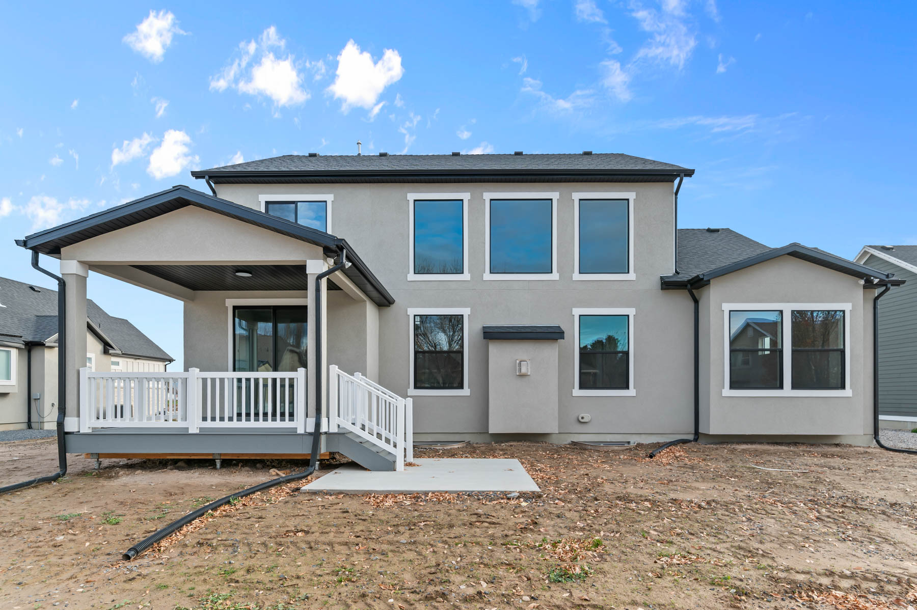 Rear view of house featuring a patio, a wooden deck, and stucco siding