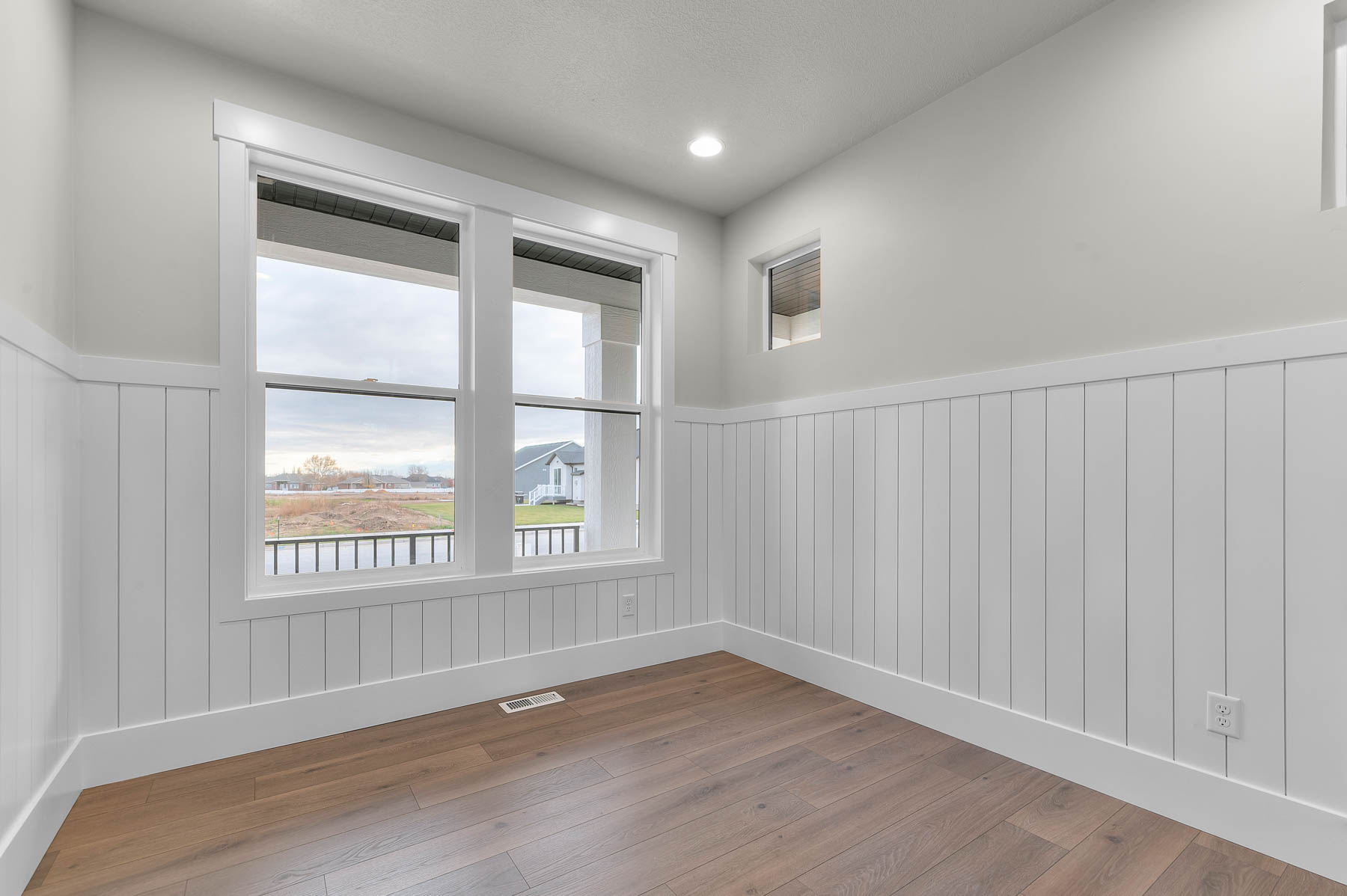 Empty room with wainscoting, wood-type flooring, and recessed lighting