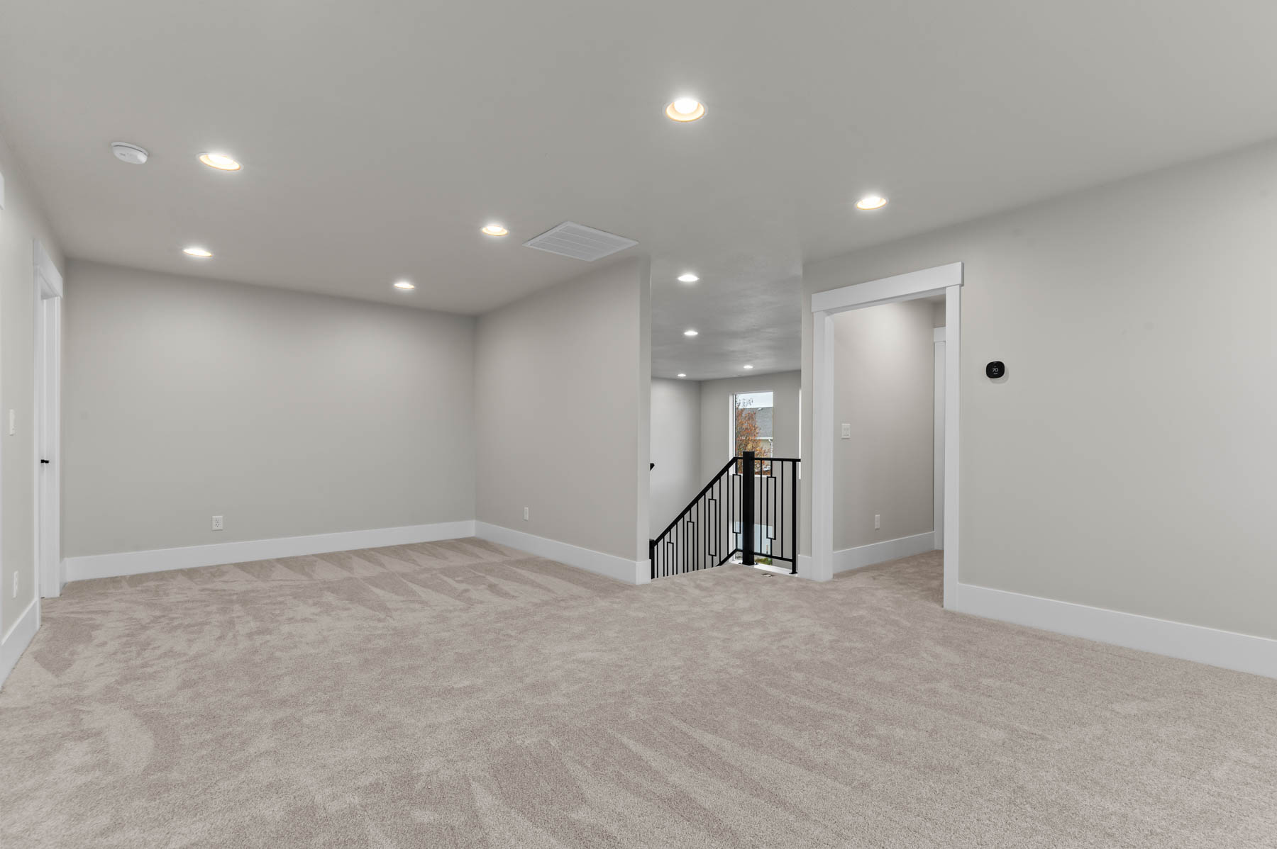 Empty room with recessed lighting and light colored carpet