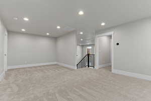 Empty room with recessed lighting and light colored carpet