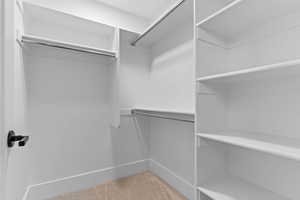 Walk in closet featuring light colored carpet