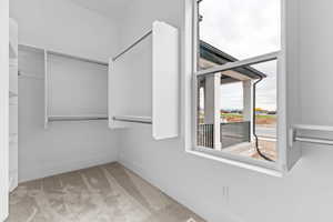 Walk in closet with light carpet