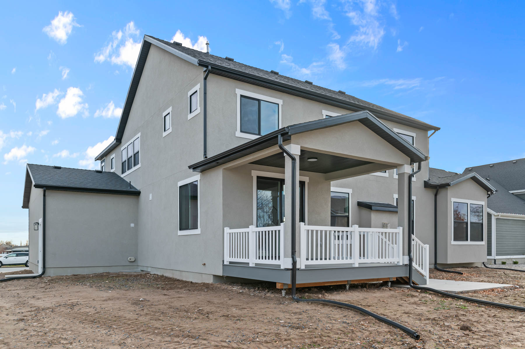 Back of house featuring a wooden deck and stucco siding